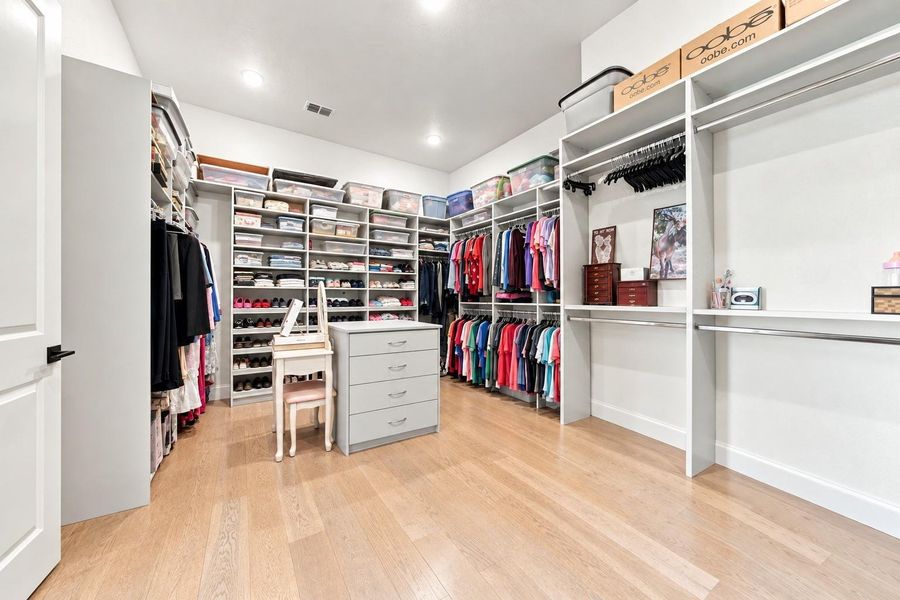 This expansive walk-in closet delivers with custom shelving on every wall, a center dresser island, and plenty of space to keep everything organized and on display.