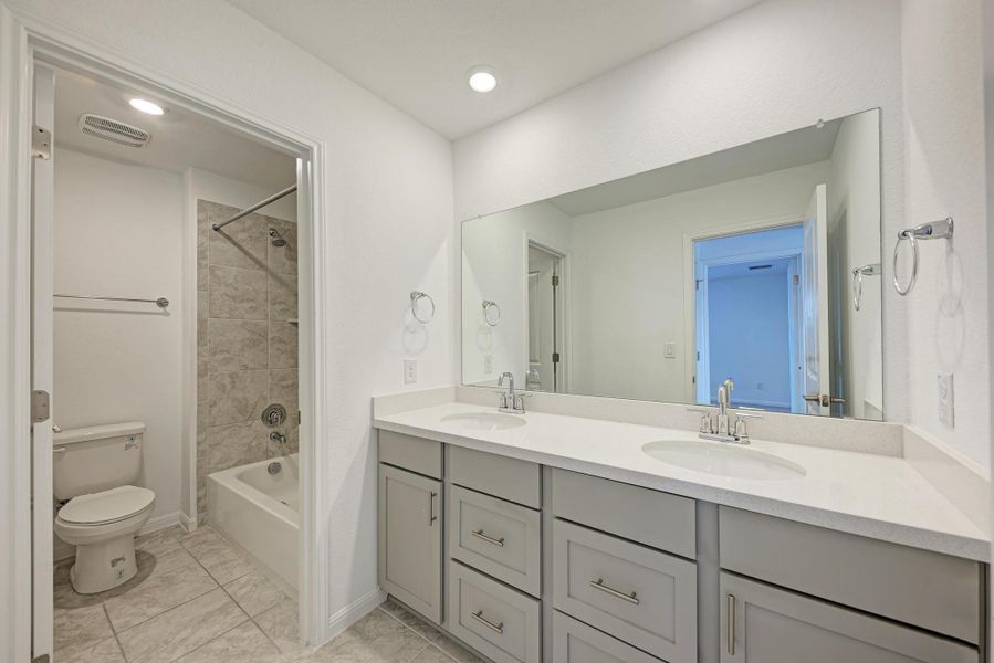 Dual vanities with ample counter space offer practical elegance in this well-appointed bathroom.