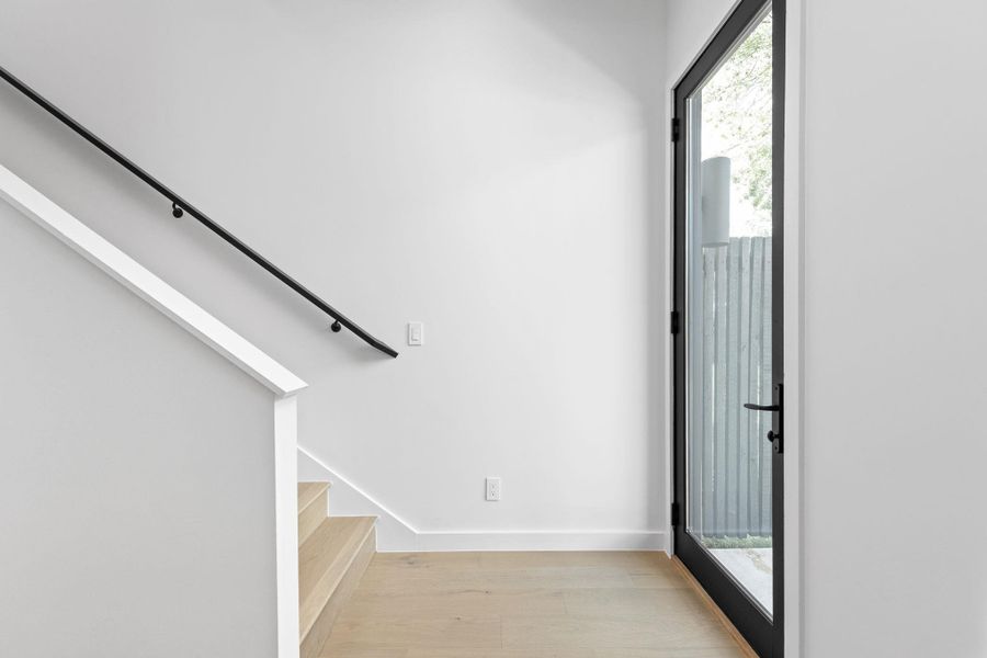 Foyer with light wood-type flooring, stairs, and healthy amount of natural light