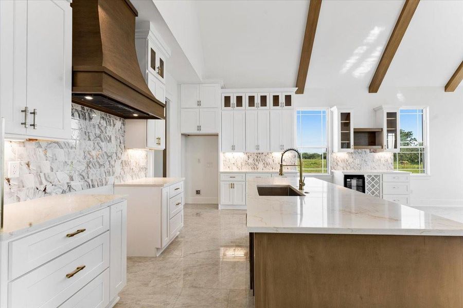 Kitchen view featuring custom cabinetry, oversized island, and ample workspace. Kitchen view featuring custom cabinetry, oversized island, and ample workspace.