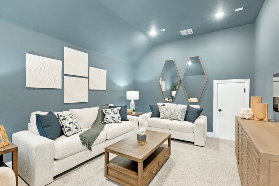 Living room with vaulted ceiling, blue walls, two white sofas, and a wood coffee table Living room with vaulted ceiling, blue walls, two white sofas, and a wood coffee table