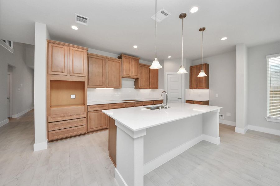 This generously spacious kitchen is a dream realized! With a massive granite island, high ceilings, soft close cabinets, granite countertops, stainless steel appliances, a sleek tile backsplash, recessed lighting, and an extended counter area, it offers both style and practicality. All this opens up to the expansive family room, creating a perfect hub for gatherings. Sample photo of completed home with similar floor plan. Actual colors and selections may vary. This generously spacious kitchen is a dream realized! With a massive granite island, high ceilings, soft close cabinets, granite countertops, stainless steel appliances, a sleek tile backsplash, recessed lighting, and an extended counter area, it offers both style and practicality. All this opens up to the expansive family room, creating a perfect hub for gatherings. Sample photo of completed home with similar floor plan. Actual colors and selections may vary.