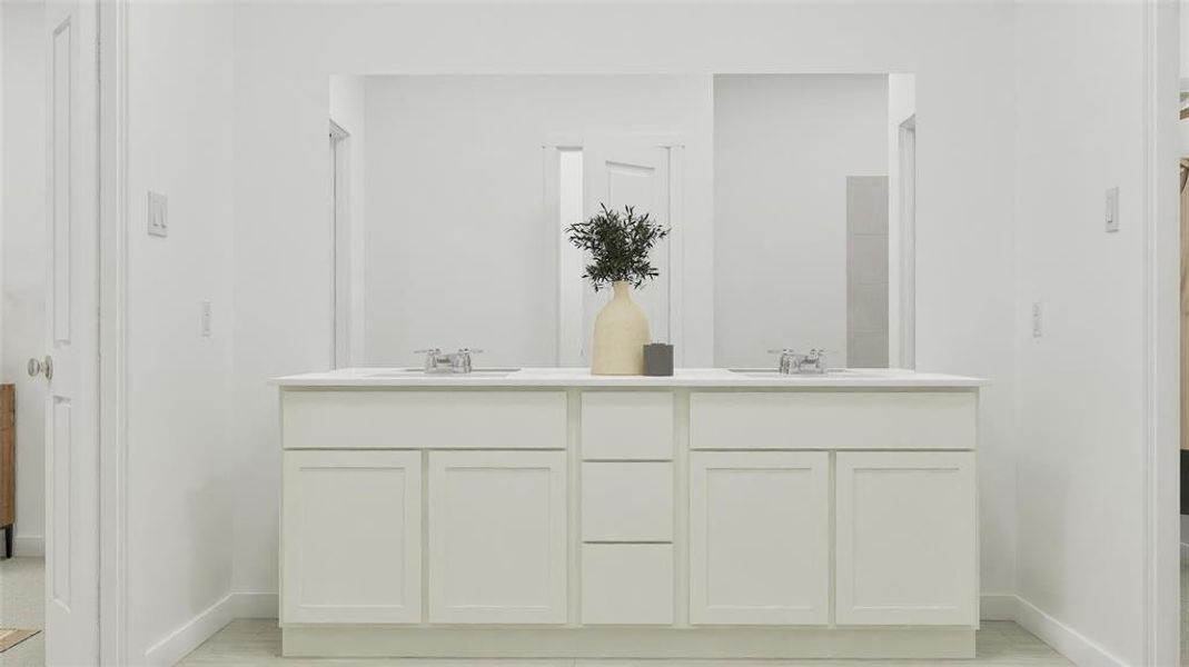 Bathroom featuring double vanity and baseboards
