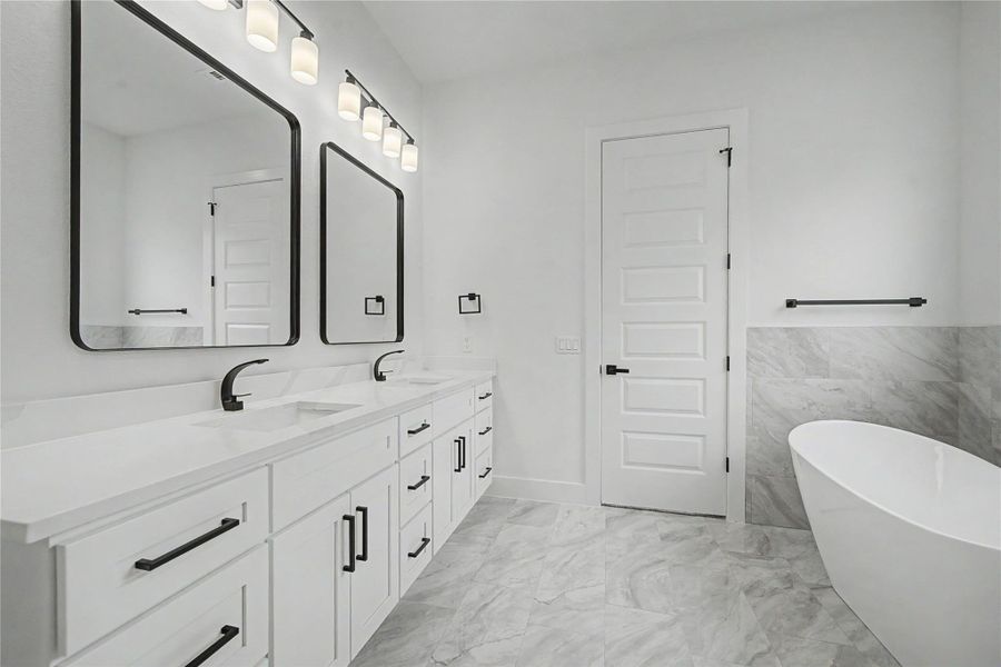 Dual-sink vanity with modern black fixtures, framed mirrors, and generous cabinet storage.