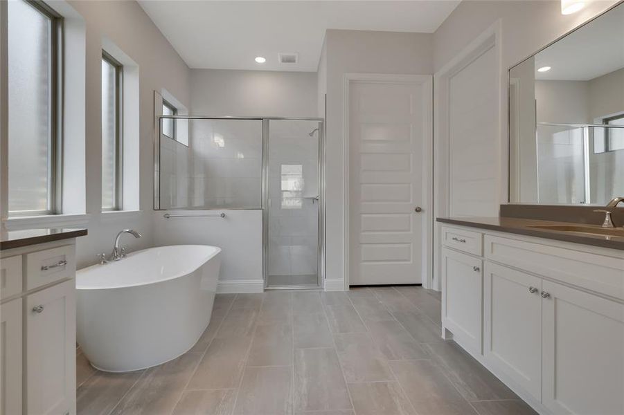 Bathroom with shower with separate bathtub, tile patterned floors, and vanity