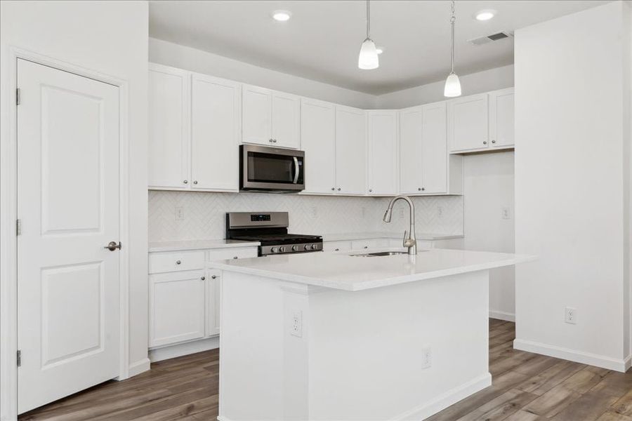 A kitchen with white cabinets.