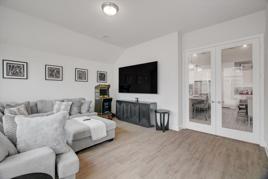 The spacious 17×14 game room sits just off the dining area and is accessed through elegant French doors, offering an inviting extension of the main living space. It provides ample room for hosting, entertainment, or a second living area, making it a versatile highlight of the home.