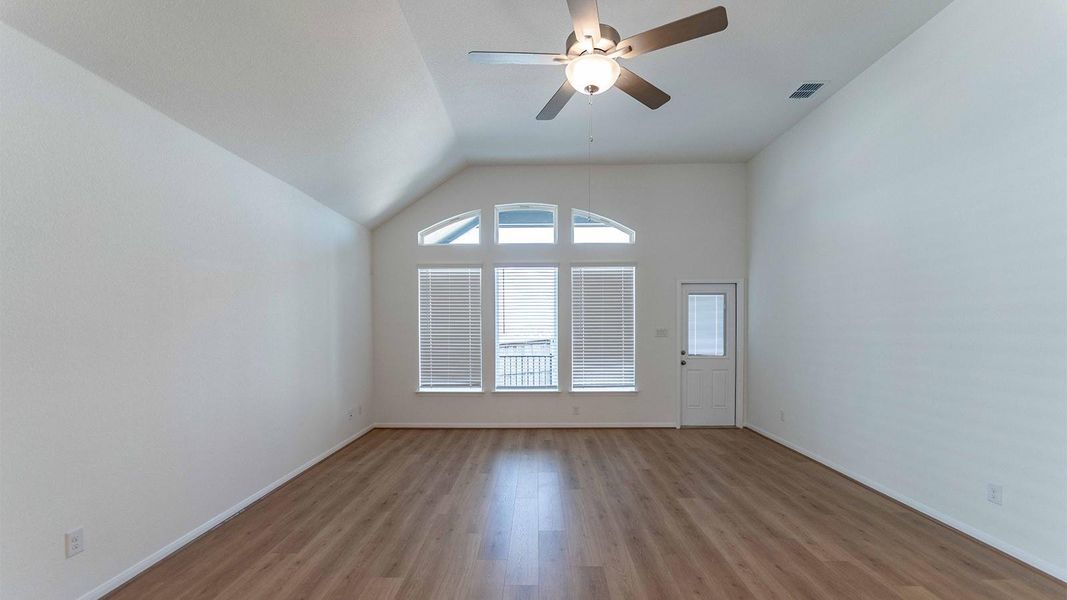 Spare room with wood finished floors, ceiling fan, and lofted ceiling
