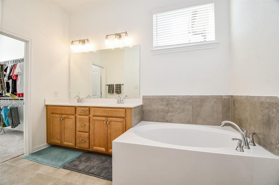 The owner's ensuite bathroom offers everything you need to start your day with ease. A dual sink vanity with ample storage, a relaxing soaking tub, and a full walk-in shower create the perfect private retreat.