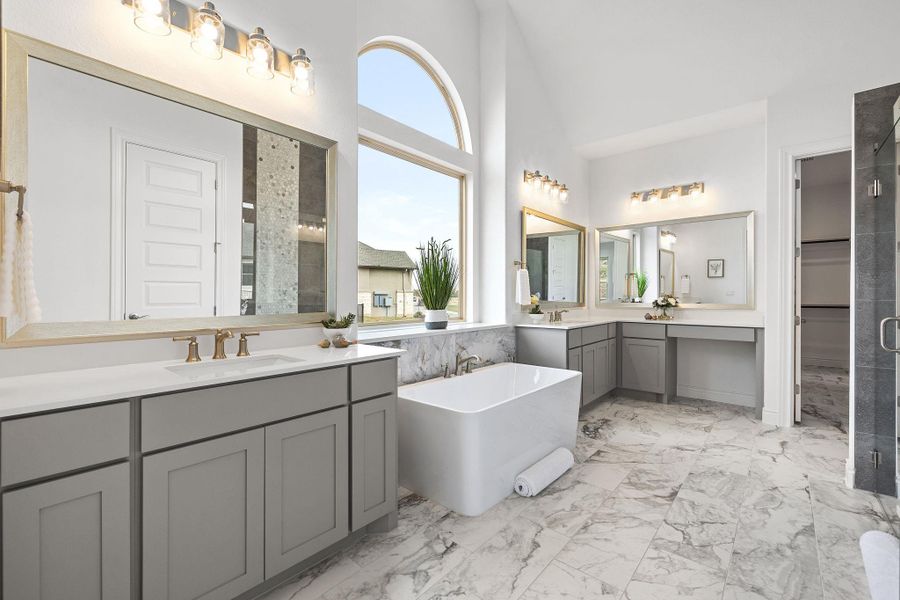 Full bath featuring marble look tiles, vanity, a freestanding tub, and an enclosed shower