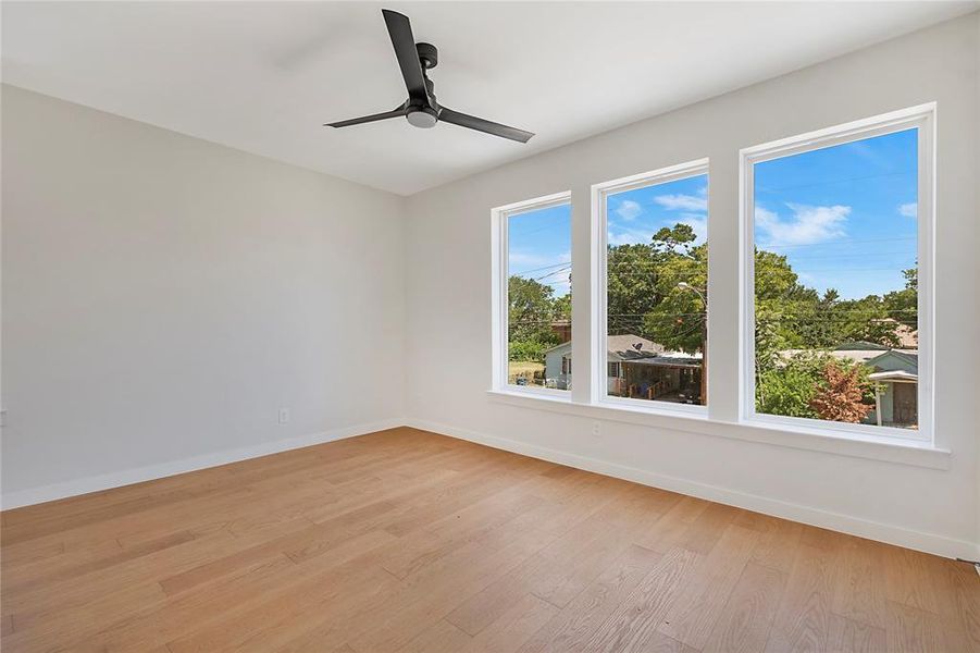 Bedroom with light hardwood / wood-style floors and ceiling fan