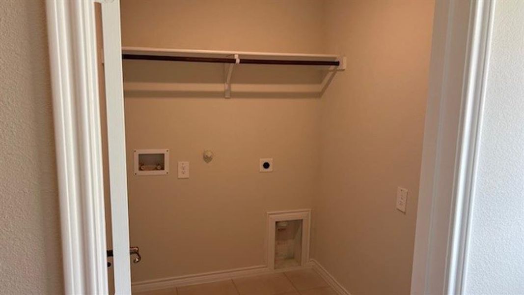 Washroom with gas dryer hookup, hookup for an electric dryer, tile patterned flooring, and hookup for a washing machine Washroom with gas dryer hookup, hookup for an electric dryer, tile patterned flooring, and hookup for a washing machine