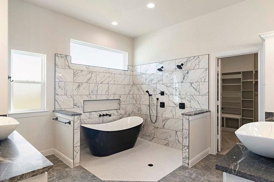 Bathroom with walk in shower, a spacious closet, a freestanding tub, vanity, and recessed lighting