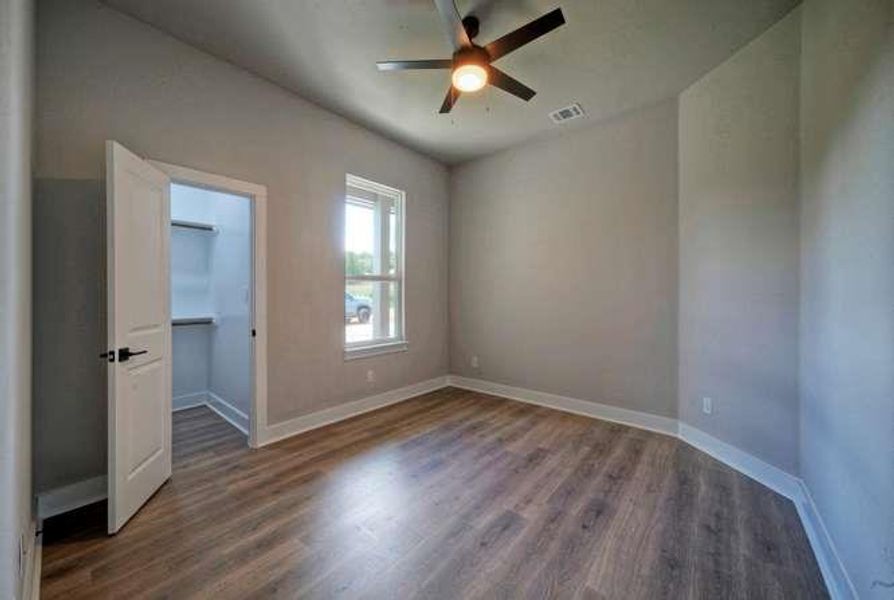 Laminate flooring and a ceiling fan create a comfortable atmosphere in this inviting room.
