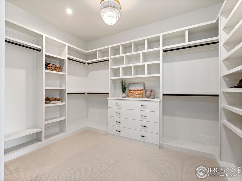 Oversized primary closet with access to the laundry room