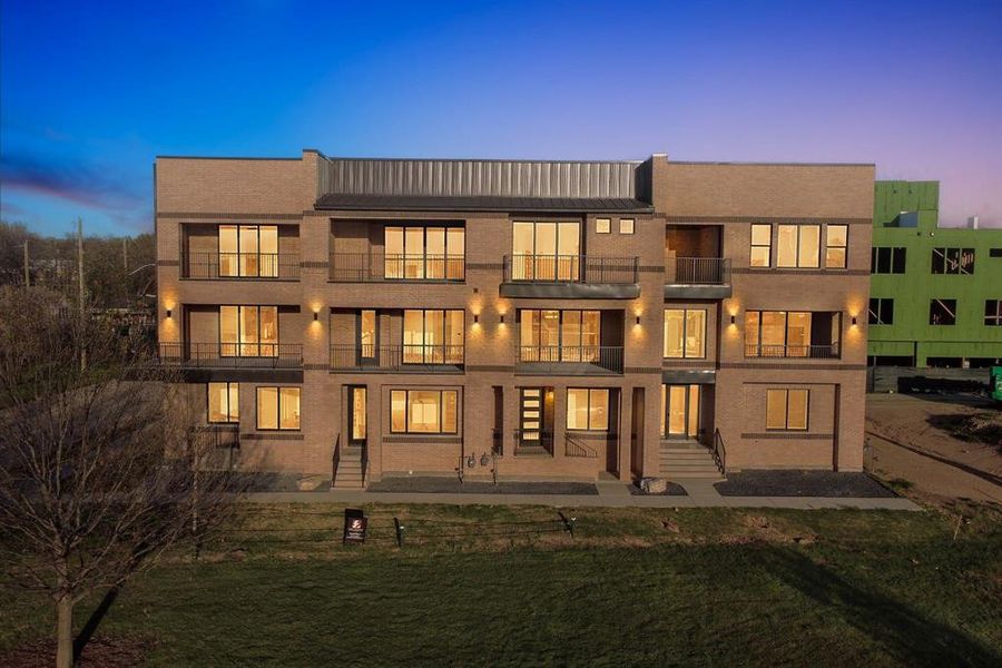 Back of property featuring a lawn and a balcony