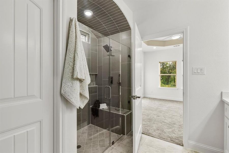 Bathroom with a shower with door, vanity, and tile patterned flooring