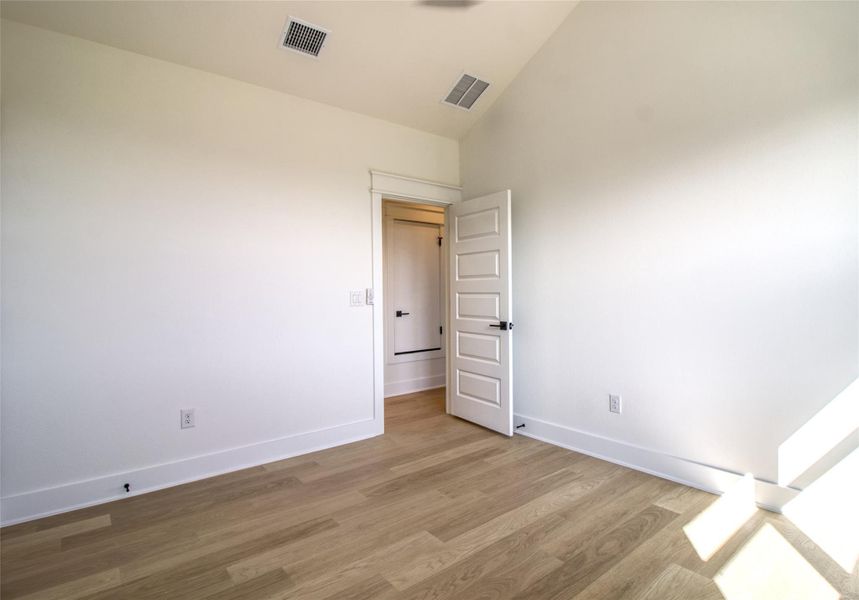 Bedroom featuring lofted ceiling and wood finished floors