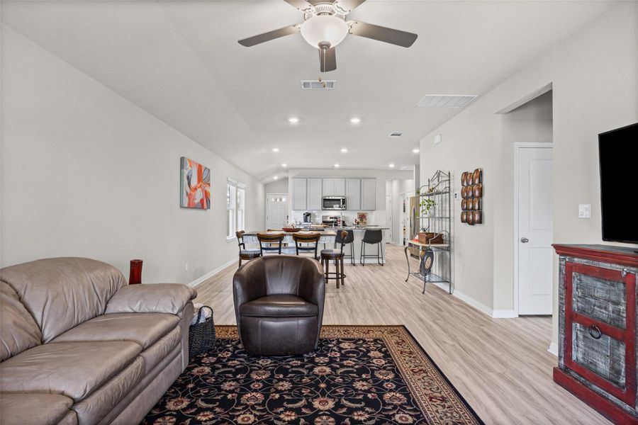 Smooth wood-look flooring connects this spacious living area directly to the kitchen.