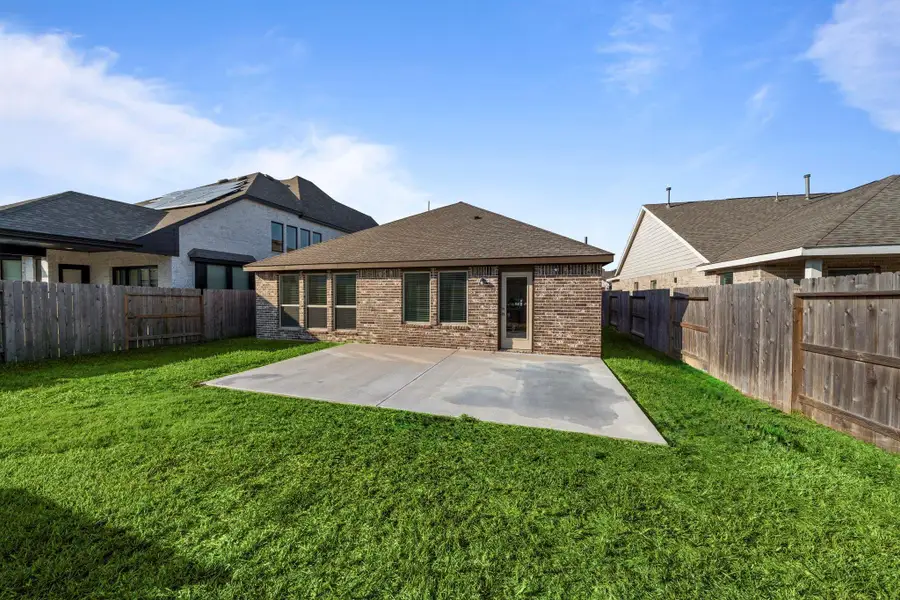 The spacious extended concrete patio is perfect for grilling, outdoor dinners, or setting up a cozy lounge area. The large grassy yard is fully fenced, offering privacy and plenty of room for kids, pets, or weekend gardening projects.