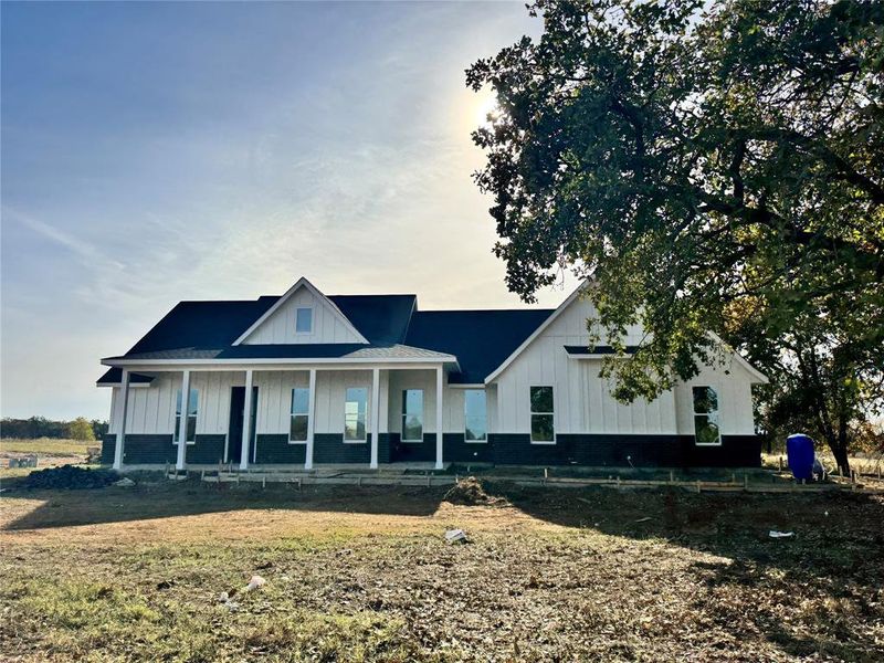 View of front of property featuring a porch and a front yard