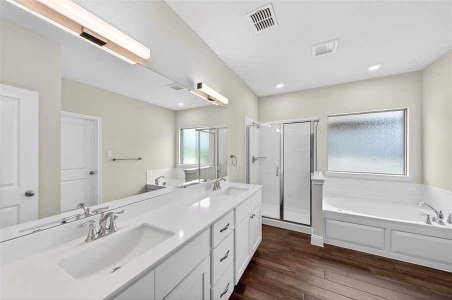 Bathroom featuring a dual vanity with undermount sinks, white cabinetry, and brushed nickel fixtures