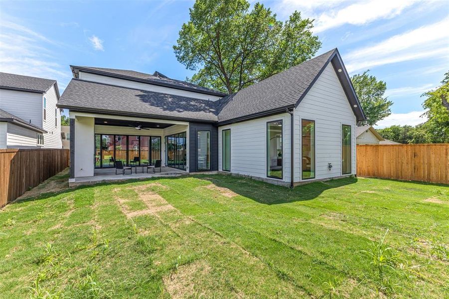 Modern white siding exterior with a dark-pitched roof and a covered patio