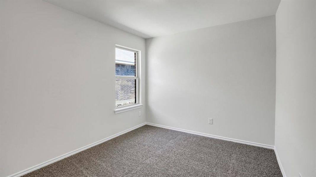 Unfurnished room featuring dark colored carpet and baseboards