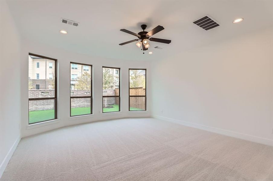 Empty room featuring ceiling fan and light colored carpet