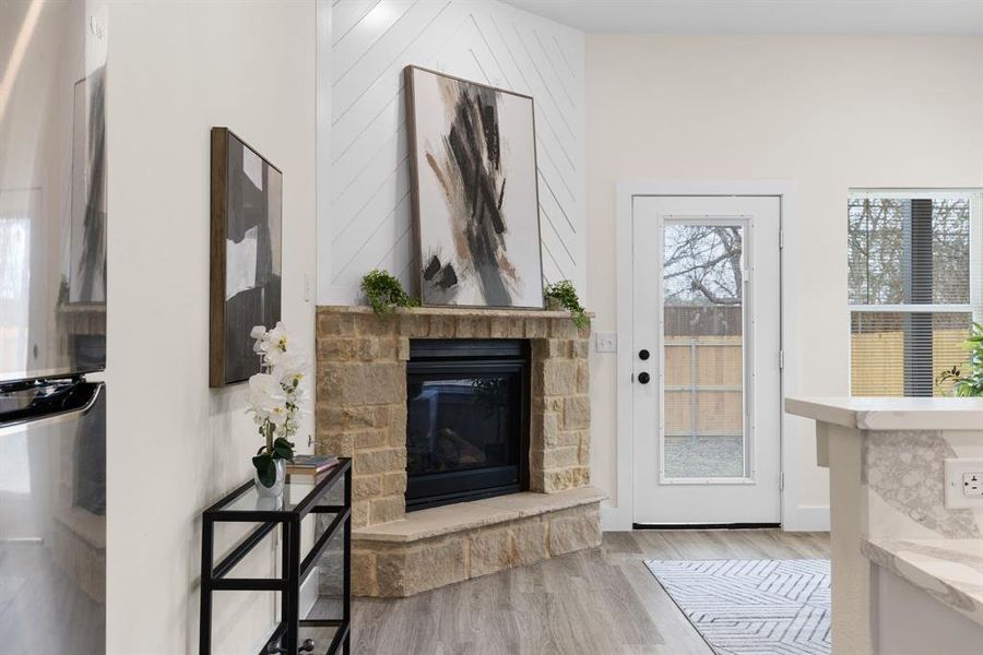 Foyer entrance with a stone fireplace and light hardwood / wood-style flooring