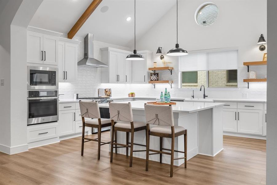 Kitchen with open shelves, white cabinets, appliances with stainless steel finishes, high vaulted ceiling, and recessed lighting