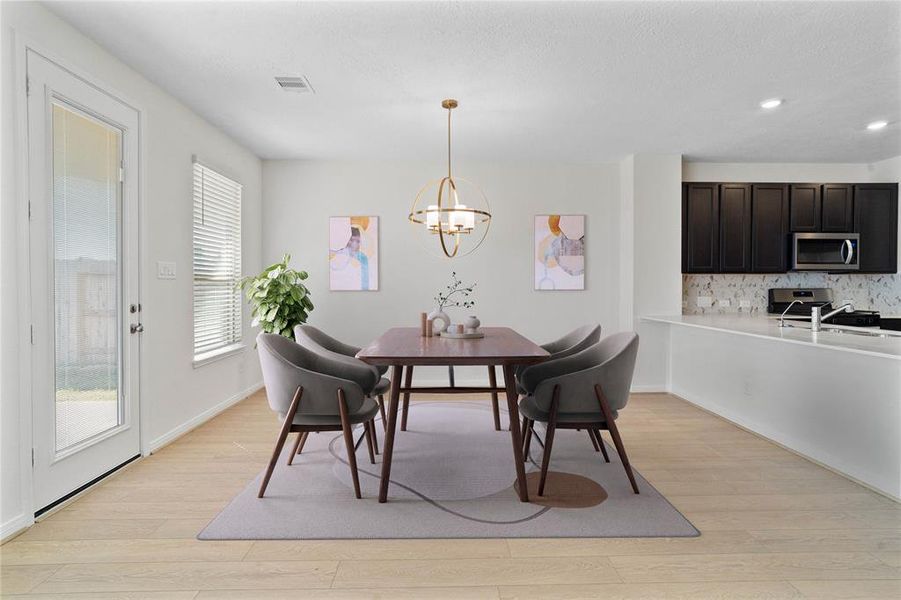 This lovely dining area is perfect for starting the day out on the right foot! This space showcases custom paint, high ceilings, chandelier lighting, large windows adding to the ample natural light, and tile flooring!