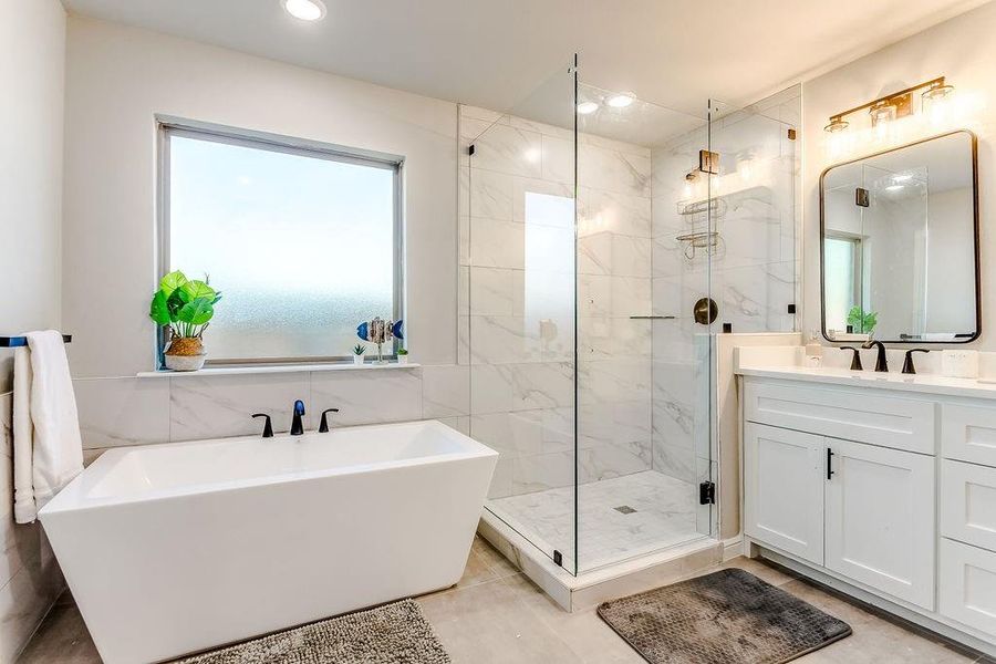 Bathroom featuring vanity and independent shower and bath