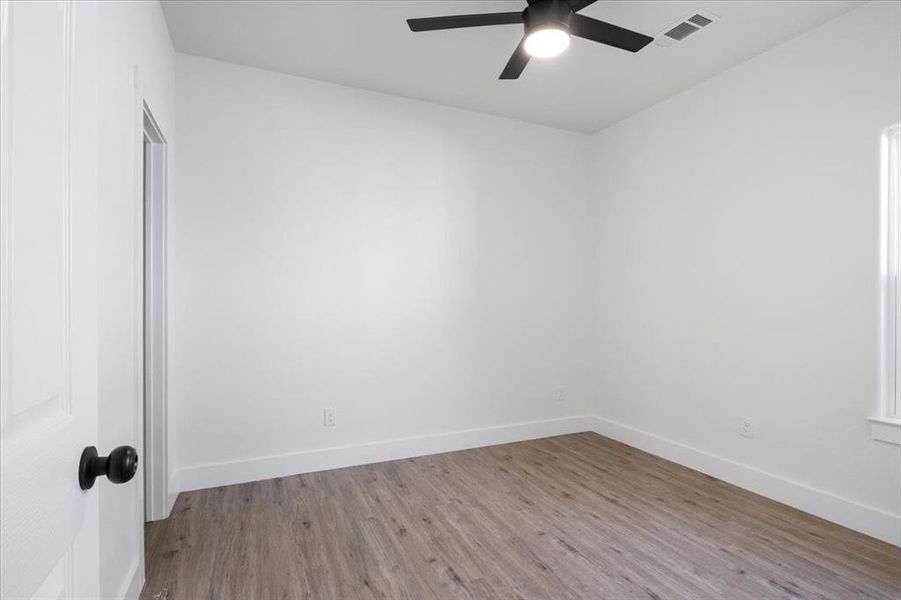 Empty room featuring light wood-type flooring and ceiling fan