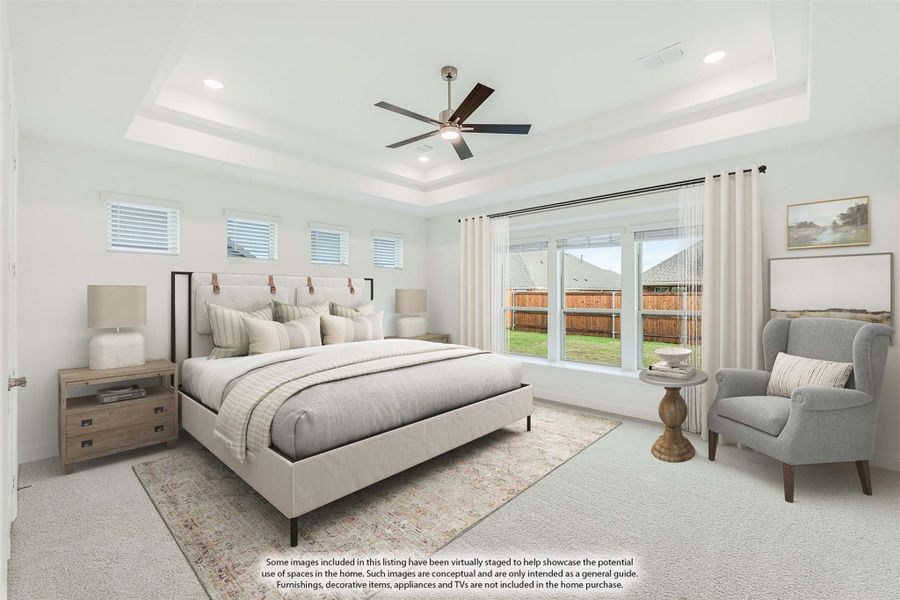 Master bedroom with tray ceiling, ceiling fan, large windows, and neutral carpet flooring