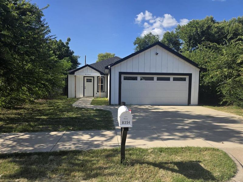 View of front facade featuring board and batten siding, an attached garage, driveway, and roof with shingles View of front facade featuring board and batten siding, an attached garage, driveway, and roof with shingles