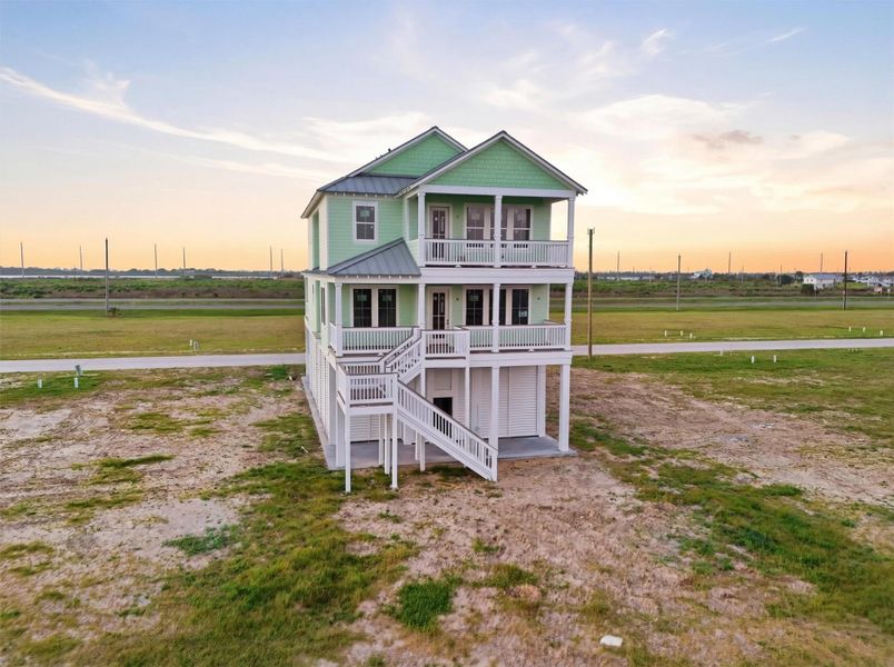 Charming elevated beach house with a pastel green facade, featuring spacious balconies and a panoramic view of the surrounding coastal landscape. Charming elevated beach house with a pastel green facade, featuring spacious balconies and a panoramic view of the surrounding coastal landscape.