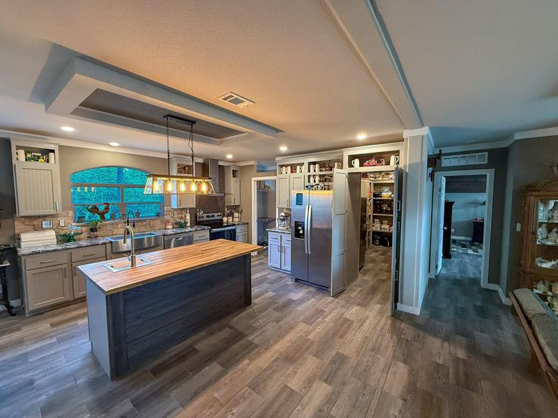 Kitchen area with butcher block island and walk-in pantry