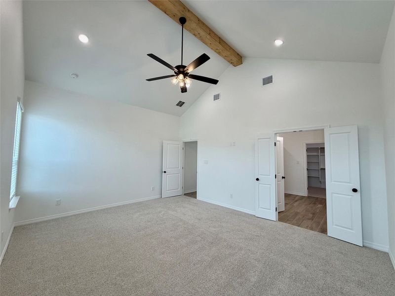 Vaulted ceiling room featuring a wood beam accent and recessed lighting