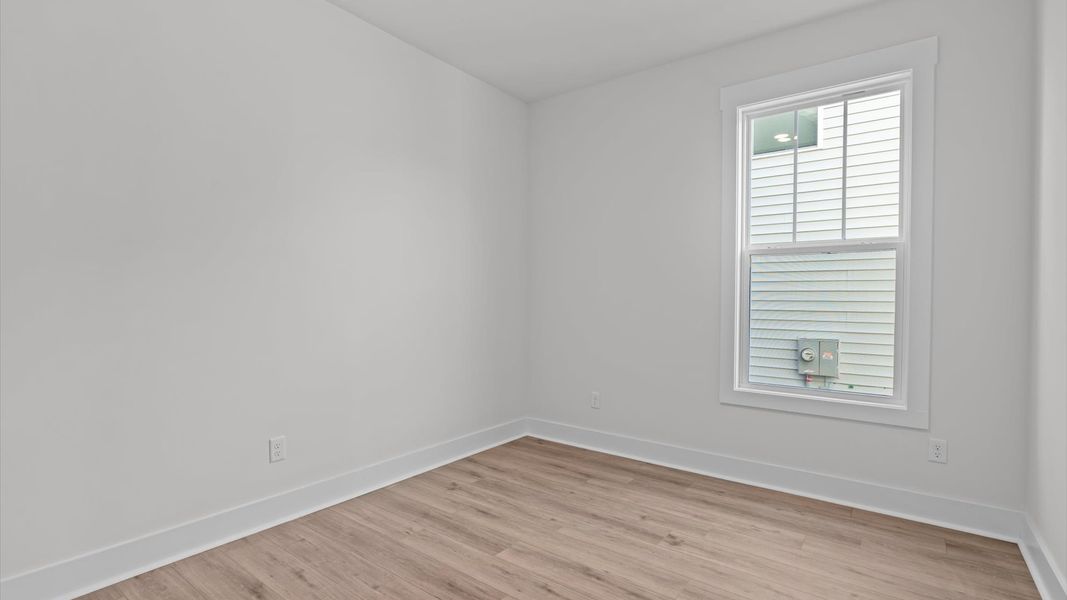 Functional secondary bedrooms with hardwood flooring and modern touches in an exceptional layout