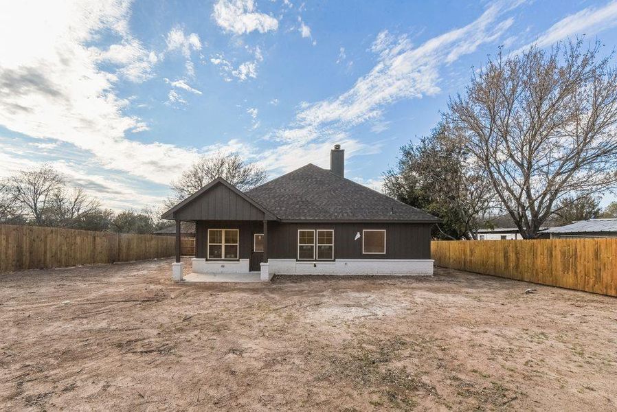 Rear view of house featuring a patio area, a shingled roof, a fenced backyard, and a chimney Rear view of house featuring a patio area, a shingled roof, a fenced backyard, and a chimney