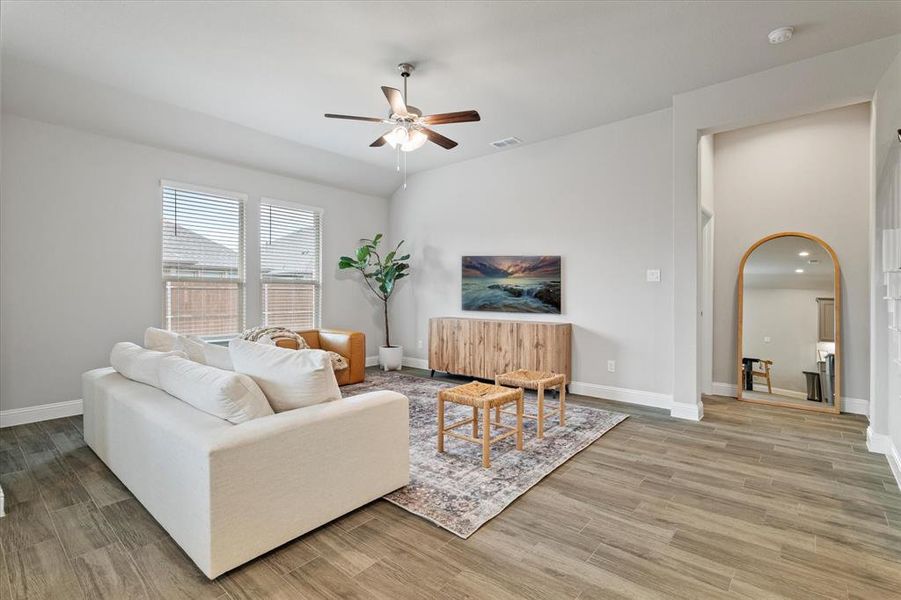 Living room with light hardwood / wood-style flooring and ceiling fan