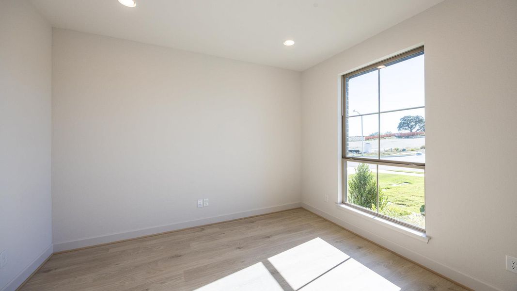 Empty room with light wood-style floors and recessed lighting Empty room with light wood-style floors and recessed lighting