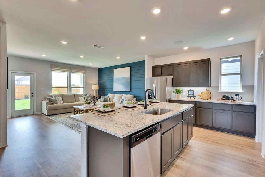An open concept design seamlessly connects a gourmet kitchen to a comfortable living area. An open concept design seamlessly connects a gourmet kitchen to a comfortable living area.