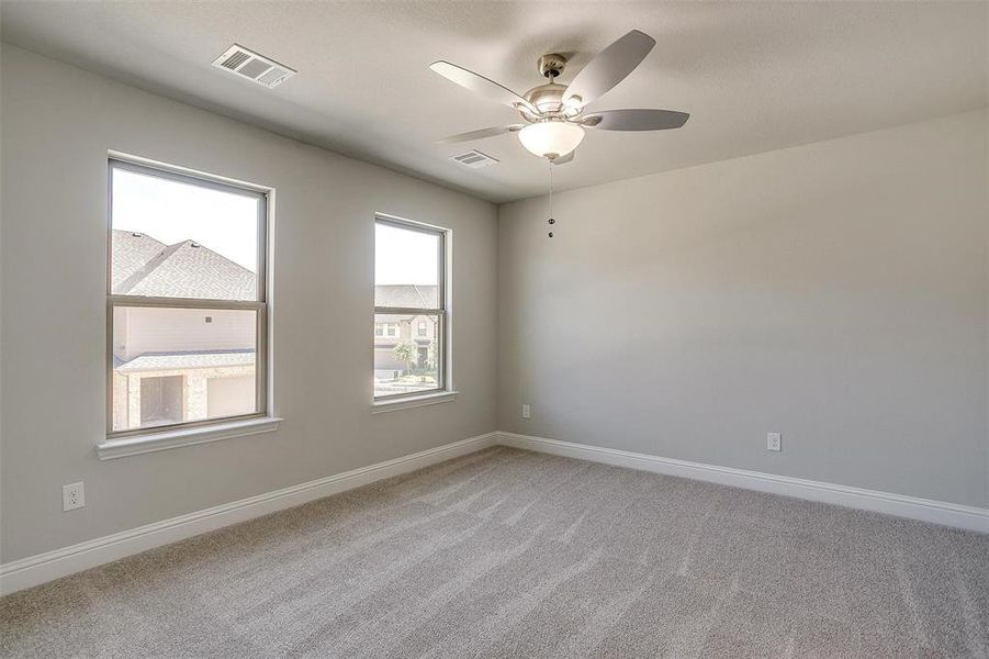 Unfurnished room with light colored carpet and ceiling fan Unfurnished room with light colored carpet and ceiling fan