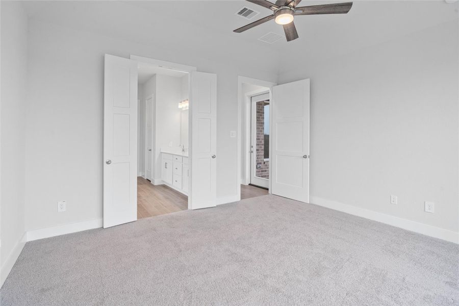 Additional view from primary bedroom looking towards the double door entrance to primary bathroom.