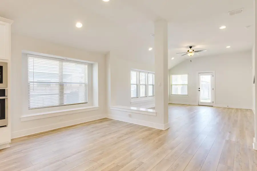 Unfurnished living room with vaulted ceiling, light wood-type flooring, recessed lighting, and a ceiling fan
