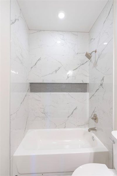 Bathroom featuring toilet and tiled shower / bath combo