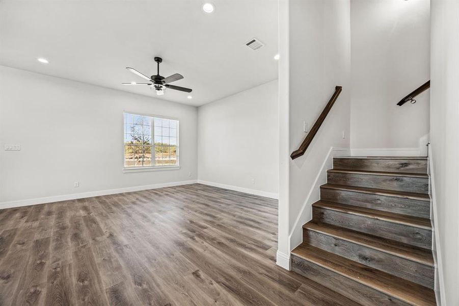 Stairway with wood-type flooring and ceiling fan