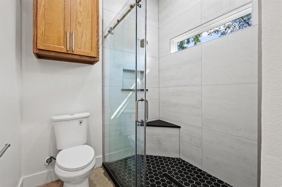 Oversized shower with dual shower heads and a bench seat